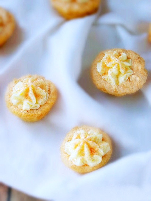 An Orange Creamsicle Cookie Cup with a fluffy orange topping